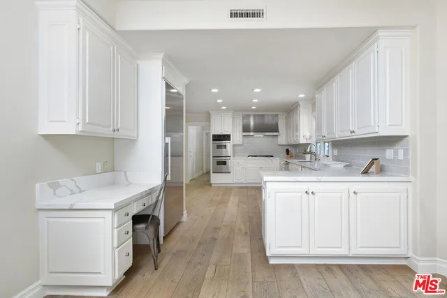 a kitchen with white cabinets and sink