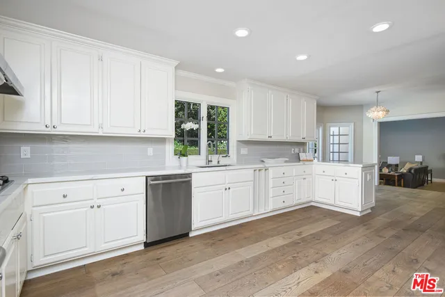 a kitchen with white cabinets white stainless steel appliances and sink