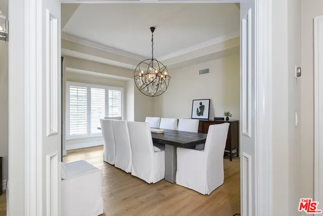 a dining room with furniture wooden floor and a chandelier