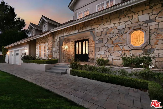 a front view of a house with a garden and plants