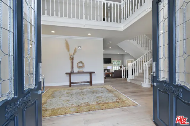 a view of a hallway with wooden floor and couches