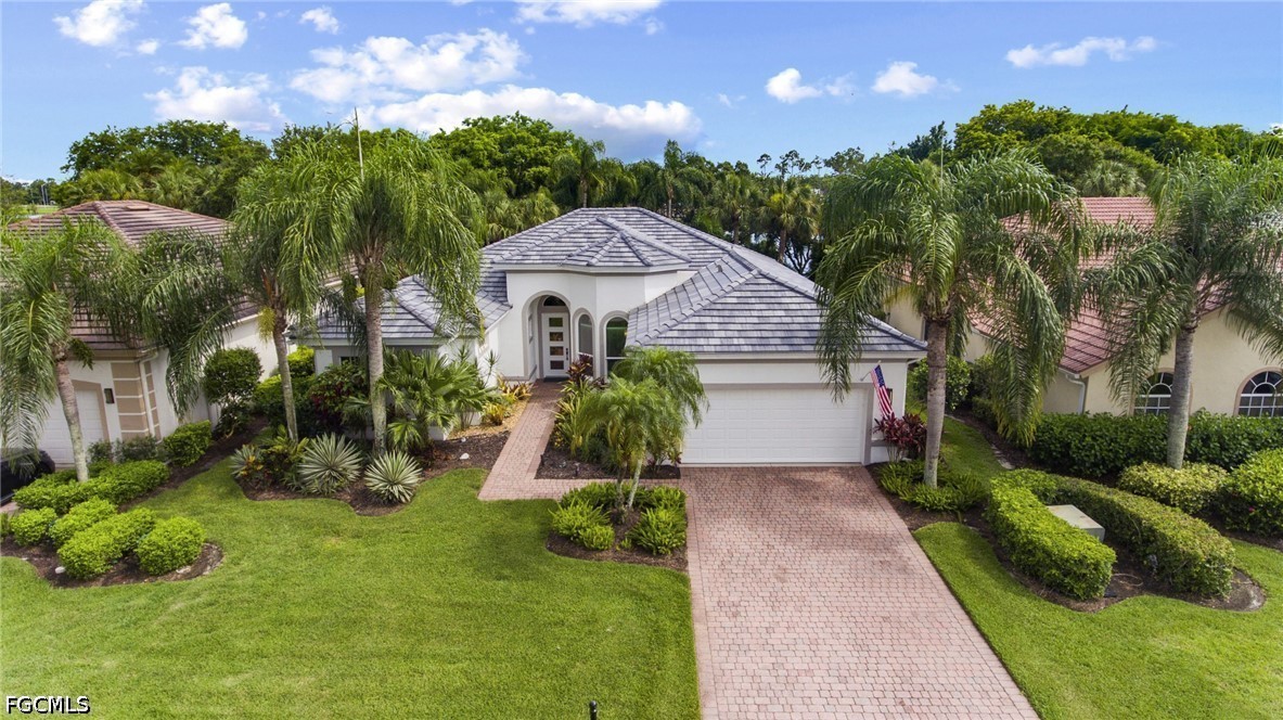9042 Bronco Court Naples, FL 34113 - Photo 34 of 50 a front view of a house with a yard and potted plants