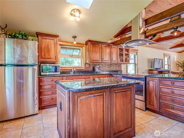 a kitchen with granite countertop a sink and a refrigerator