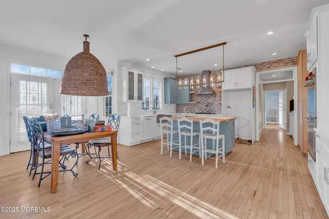 a dining room with furniture a chandelier and wooden floor