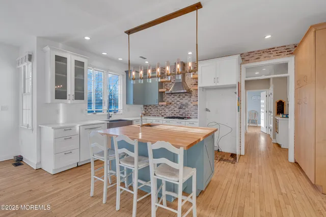 a kitchen with a wooden floor and white cabinets