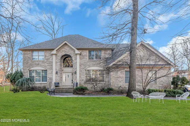 a front view of a house with a garden and trees