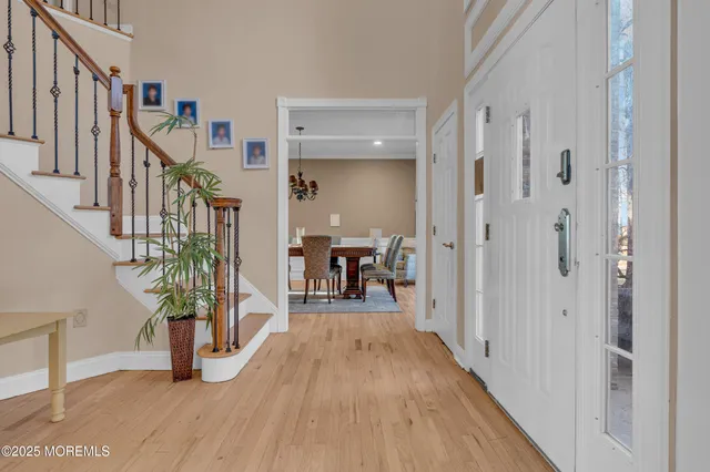 a hallway with wooden floor table and chairs