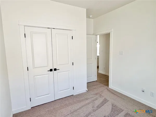 a view of an empty room with closet area