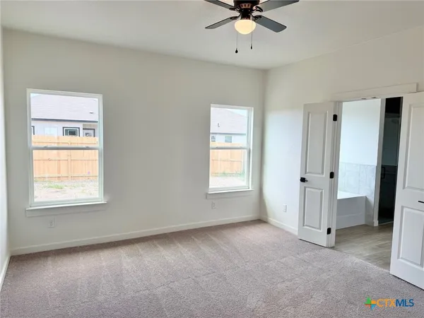 an empty room with a window and a fan