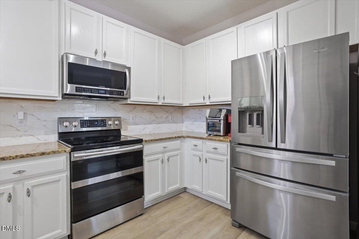 3502 Oneonta Avenue Raleigh, NC 27604 - Photo 11 of 28 a kitchen with stainless steel appliances and granite countertop white wooden cabinets