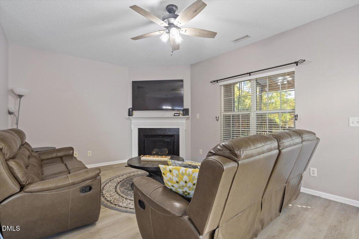 3502 Oneonta Avenue Raleigh, NC 27604 - Photo 16 of 28 a living room with furniture a fireplace and a flat screen tv