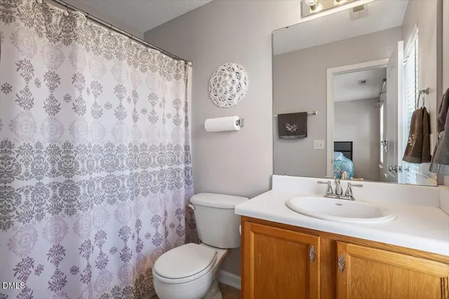 a bathroom with a sink a toilet and shower curtain