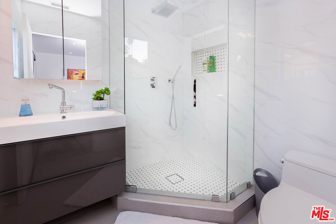 9331 Doheny Road Beverly Hills, CA 90210 - Photo 12 of 14 a bathroom with a sink and a mirror