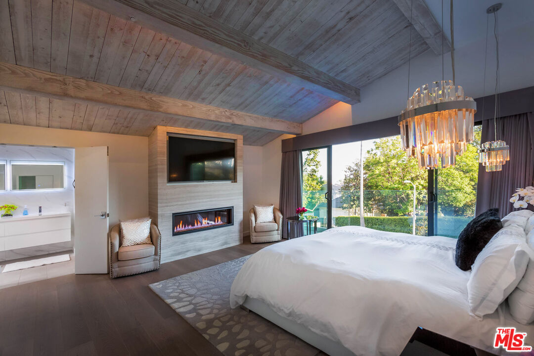 9331 Doheny Road Beverly Hills, CA 90210 - Photo 4 of 14 a bedroom with a bed and a fireplace