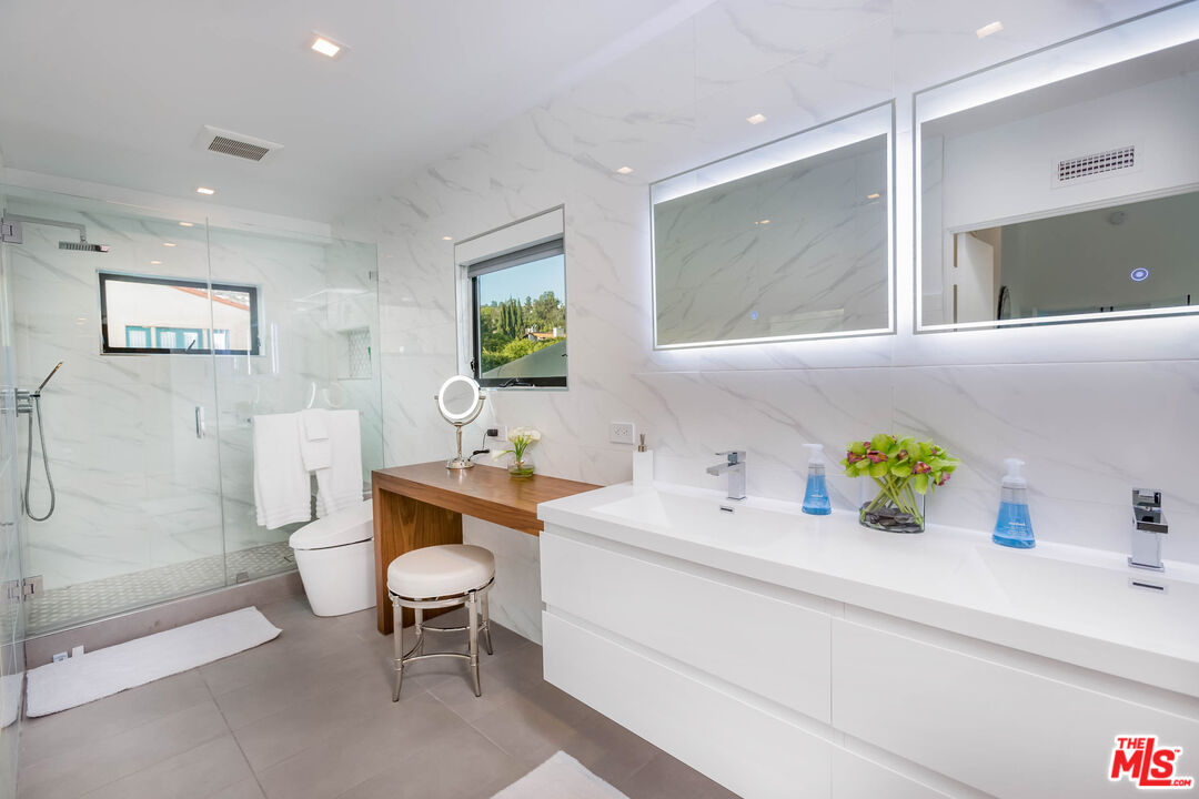 9331 Doheny Road Beverly Hills, CA 90210 - Photo 6 of 14 a bathroom with a sink a toilet and a mirror