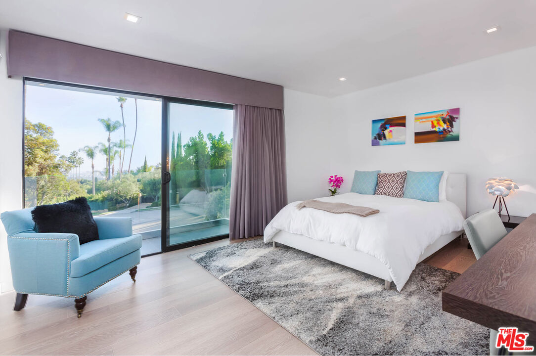 9331 Doheny Road Beverly Hills, CA 90210 - Photo 8 of 14 a bedroom with a bed couch and a large window