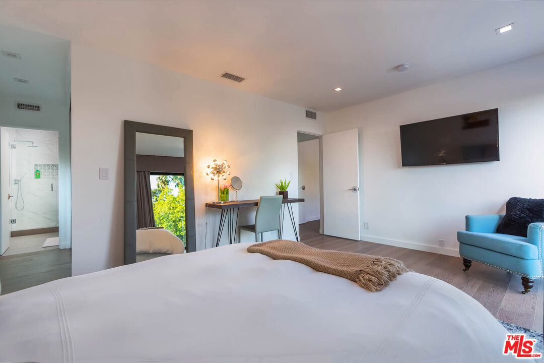 9331 Doheny Road Beverly Hills, CA 90210 - Photo 9 of 14 a bedroom with a bed and a flat screen tv