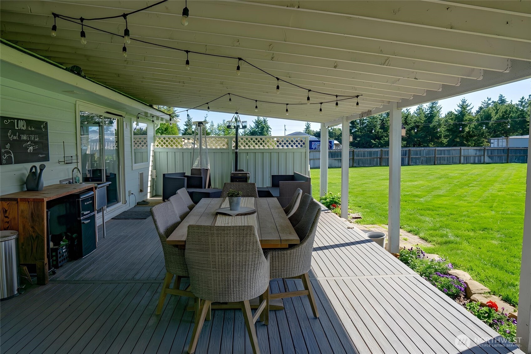 787 North Kendall Road Sequim, WA 98382 - Photo 15 of 40 a view of a patio with table and chairs under an umbrella with a garden
