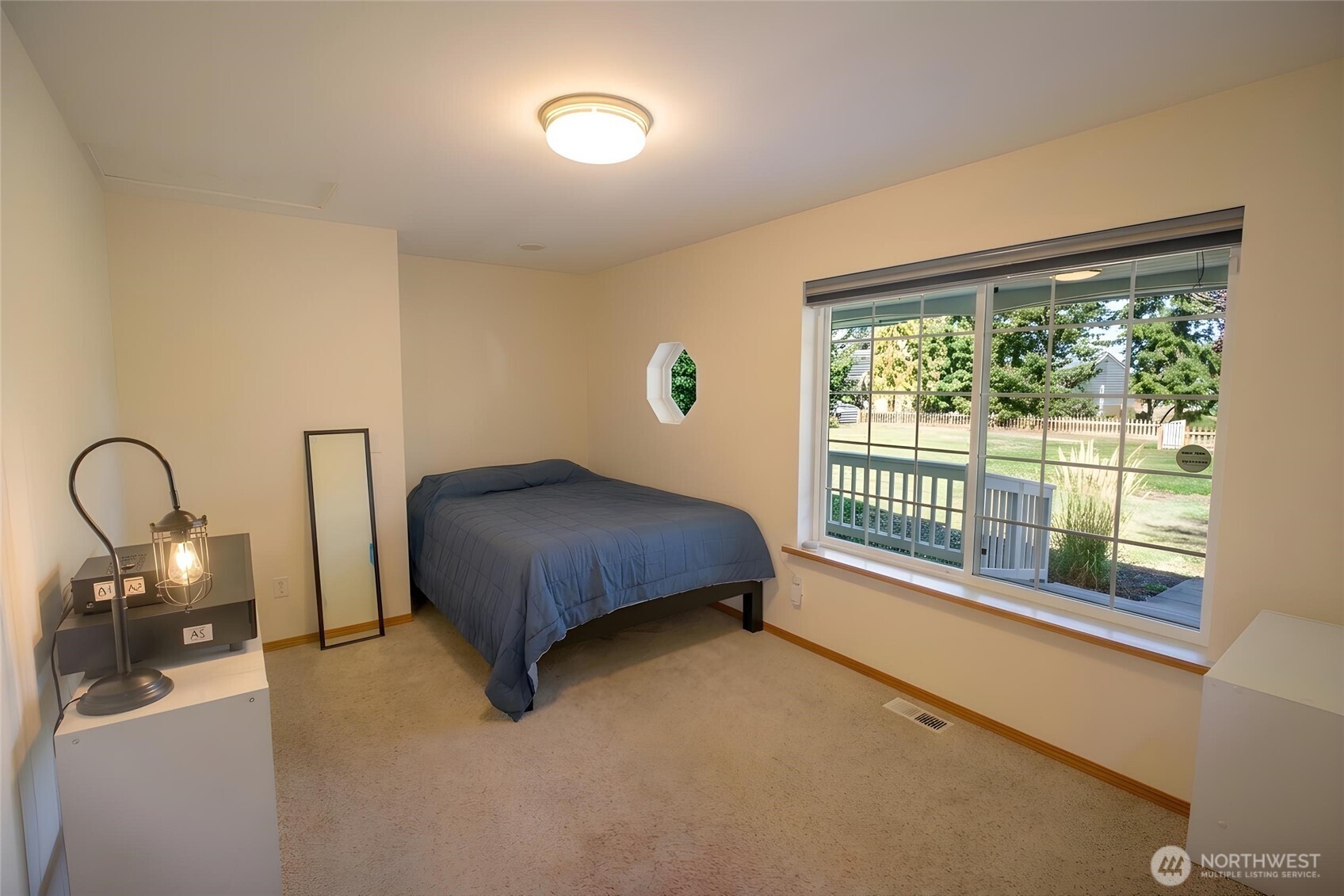 787 North Kendall Road Sequim, WA 98382 - Photo 21 of 40 a bedroom with a bed and a lamp next to a window