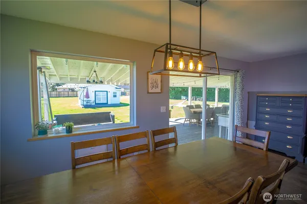 a dining room with furniture a chandelier and wooden floor