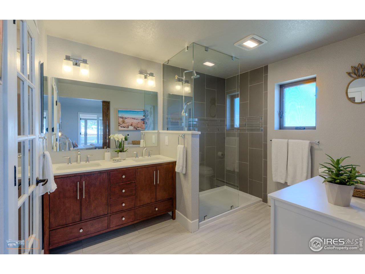 8323 West Fork Road Boulder, CO 80302 - Photo 21 of 36 a bathroom with a granite countertop sink mirror and shower