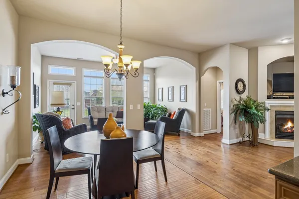 a dining room with furniture a chandelier and wooden floor