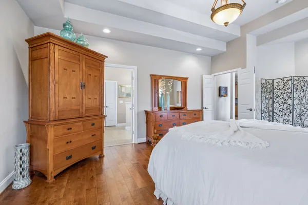 a spacious bedroom with a bed and wooden floor