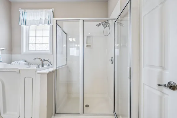 a bathroom with a granite countertop sink mirror and shower