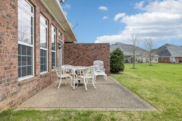 a patio with table and chairs and potted plants