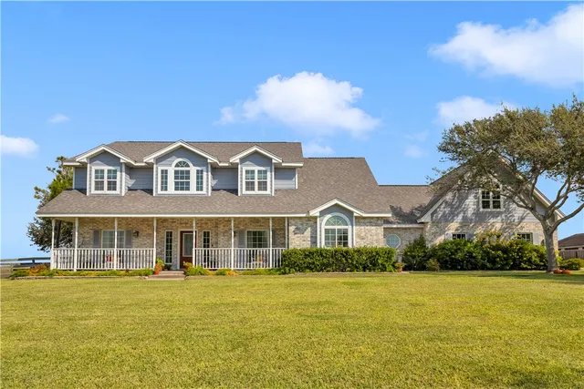 a front view of a house with a garden and swimming pool