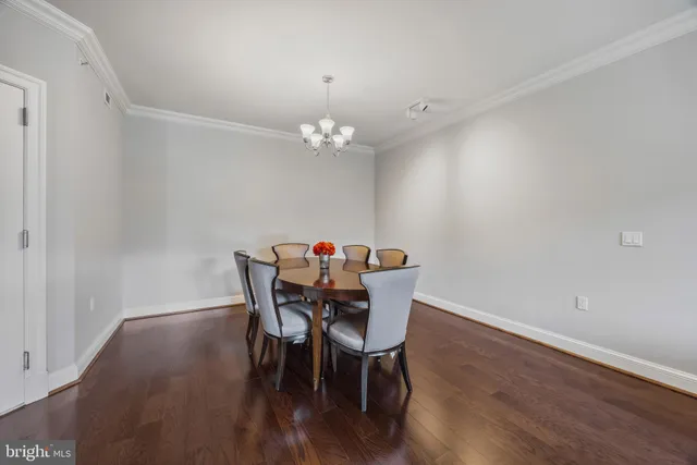 a dining room with furniture a chandelier and wooden floor