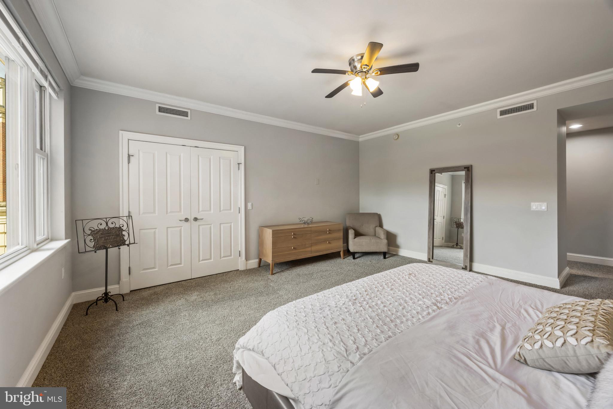 801 Key Highway, Unit 323 Baltimore, MD 21230 - Photo 26 of 56 a bedroom with a bed and a chandelier