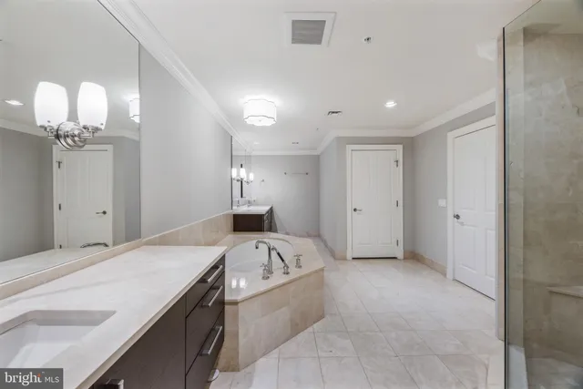 a bathroom with a tub sink shower and mirror
