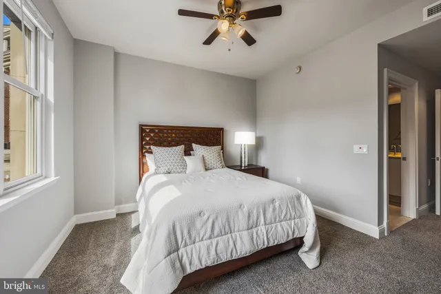 a spacious bedroom with a bed and a large window