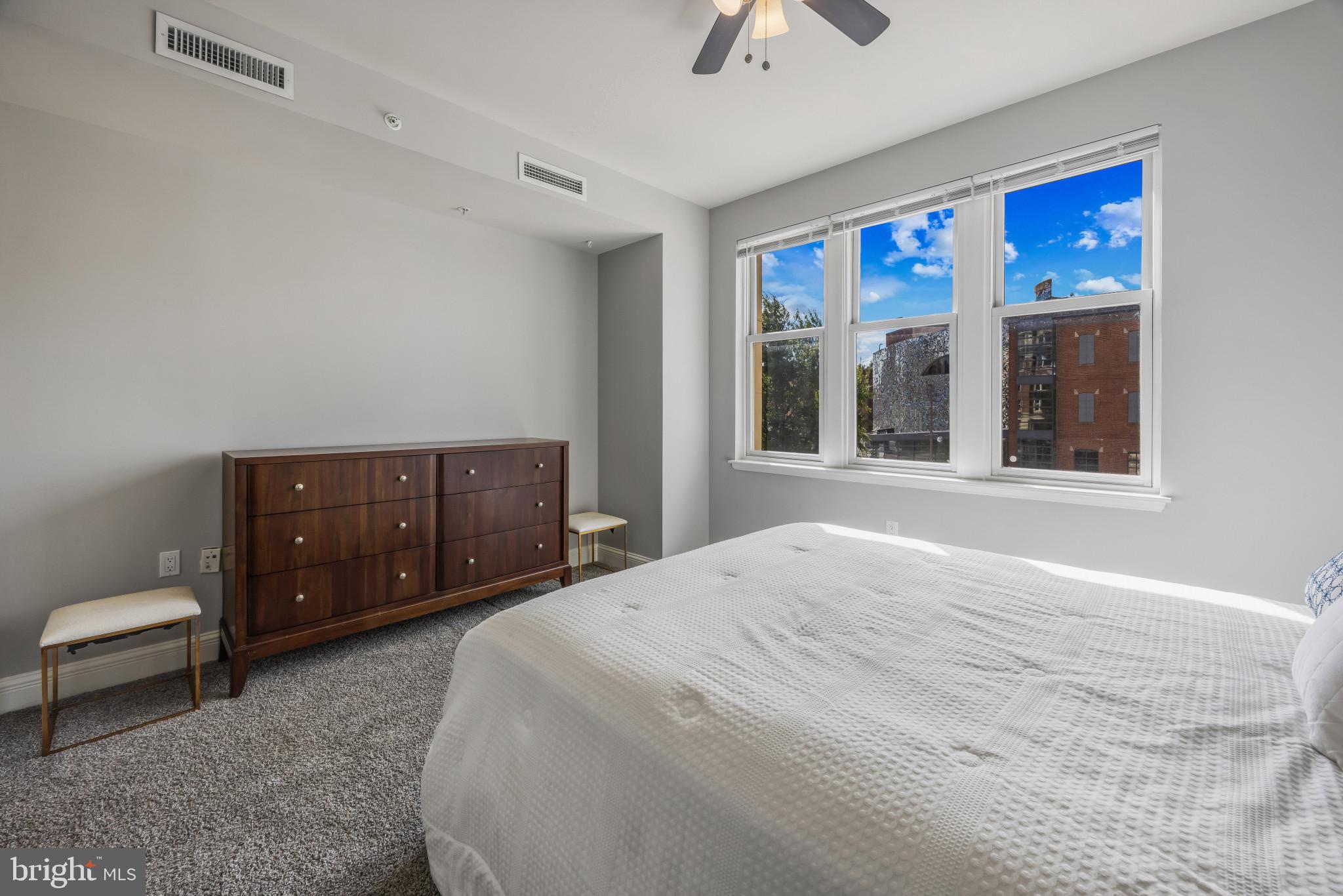 801 Key Highway, Unit 323 Baltimore, MD 21230 - Photo 37 of 56 a spacious bedroom with a bed and a large window