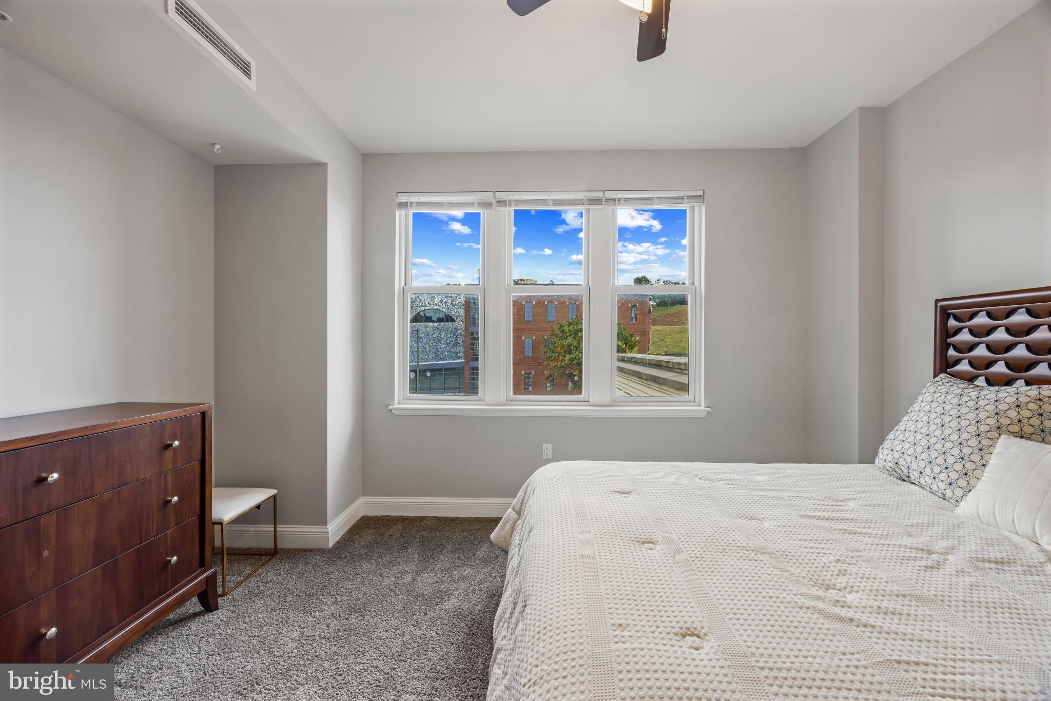 801 Key Highway, Unit 323 Baltimore, MD 21230 - Photo 38 of 56 a bedroom with a bed and a window