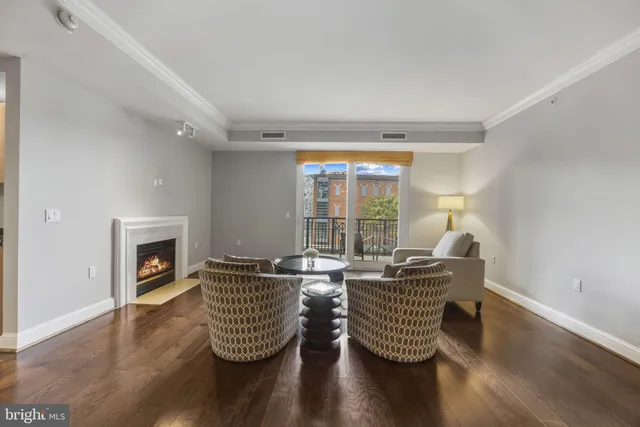 a living room with furniture floor to ceiling window and a fireplace