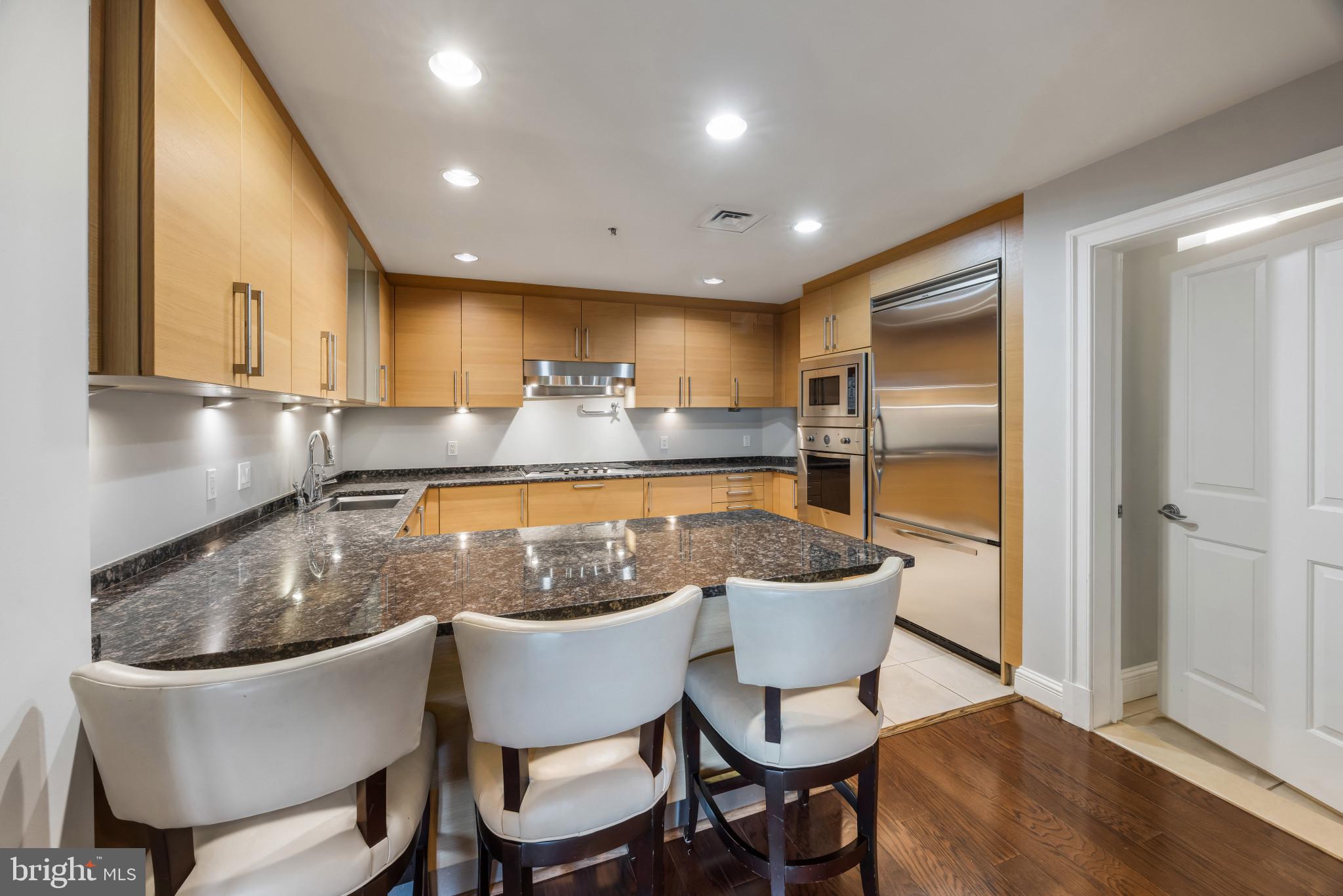 801 Key Highway, Unit 323 Baltimore, MD 21230 - Photo 10 of 56 a kitchen with a table chairs and a refrigerator