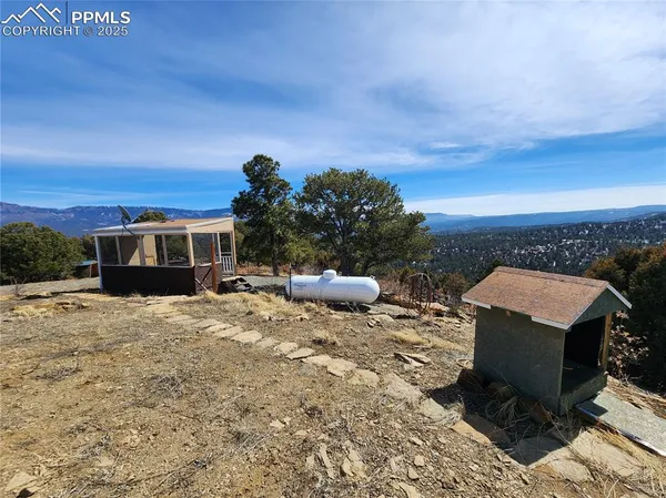 a view of a dry yard with mountains in the background