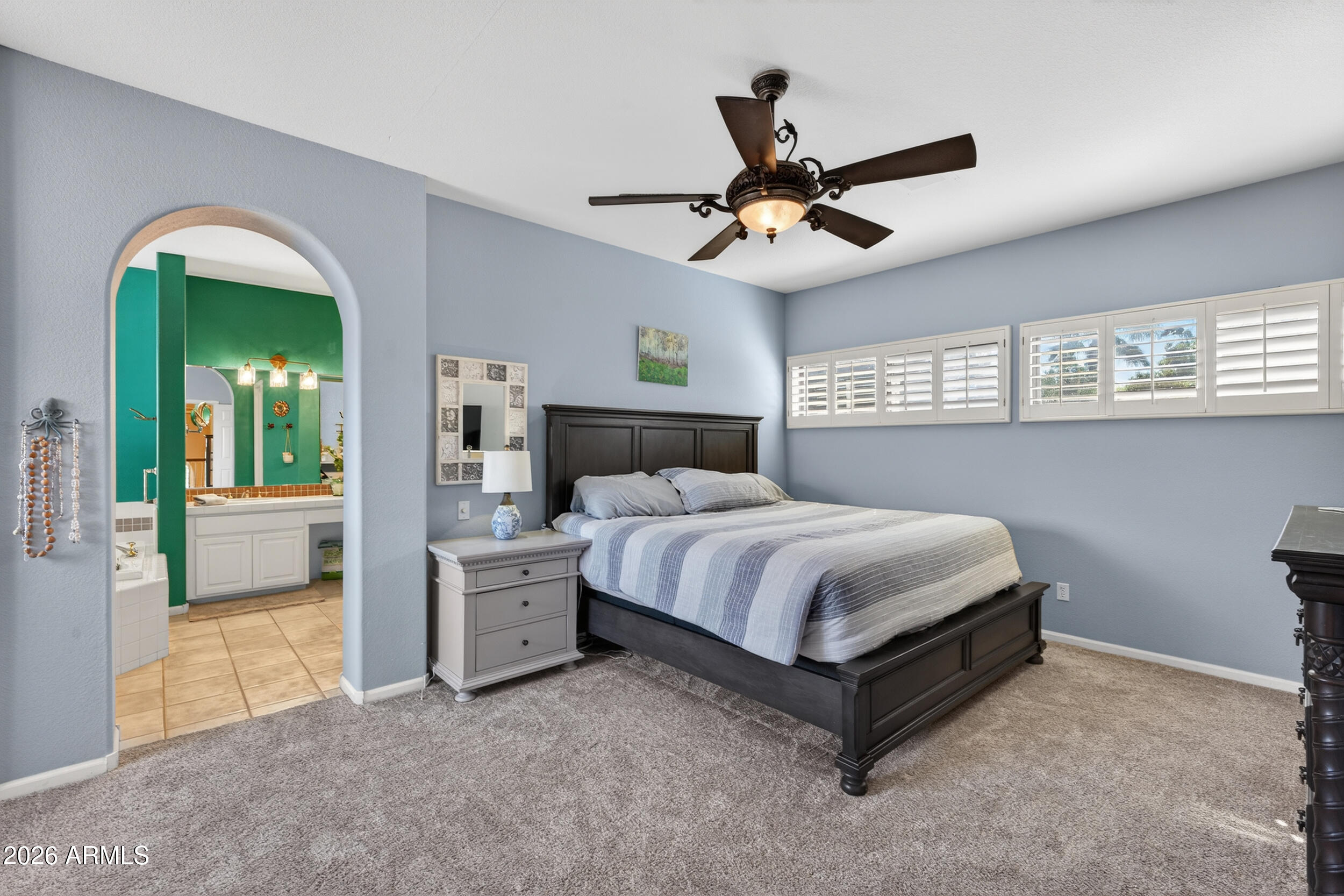 1539 East Winged Foot Road Phoenix, AZ 85022 - Photo 33 of 64 a spacious bedroom with a bed and a chandelier