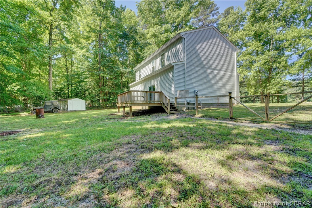 8269 Ark Road Gloucester, VA 23061 - Photo 25 of 33 View of yard featuring a storage unit and a wooden deck
