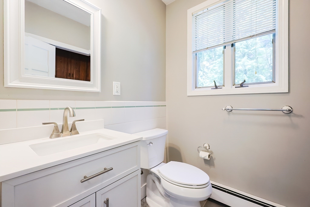 10 Prospect Street Upton, MA 01568 - Photo 14 of 41 a bathroom with a toilet a sink a mirror and a window