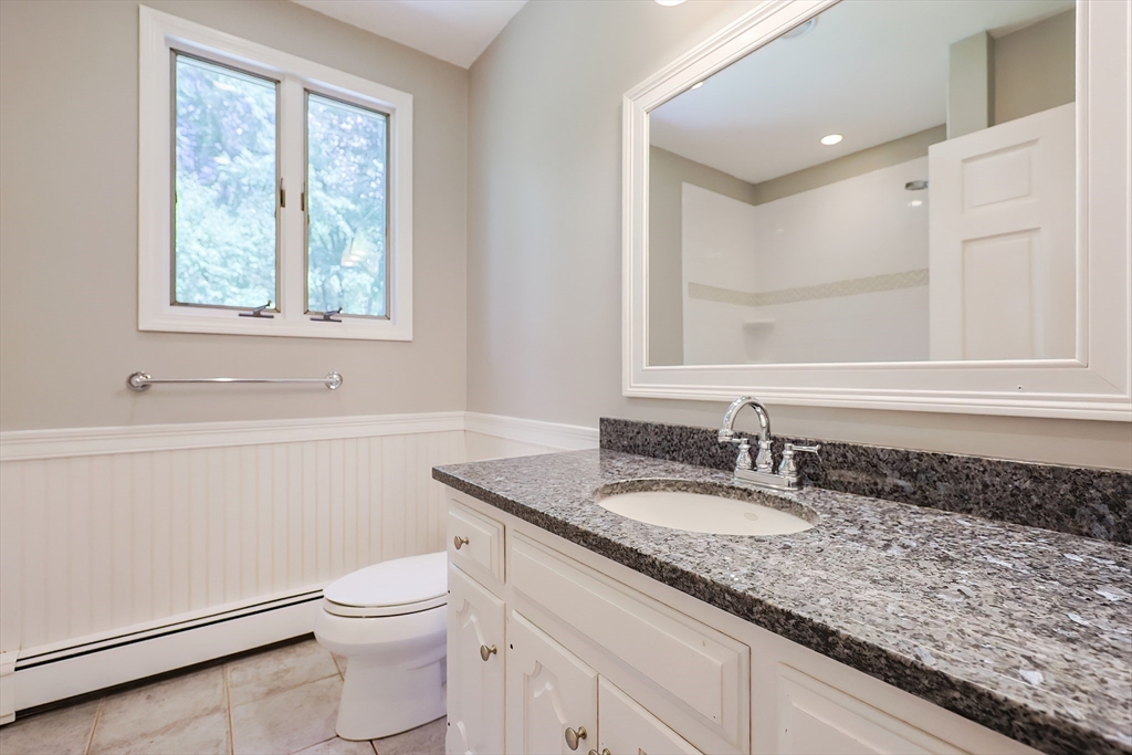 10 Prospect Street Upton, MA 01568 - Photo 26 of 41 a bathroom with a granite countertop sink a toilet and a mirror