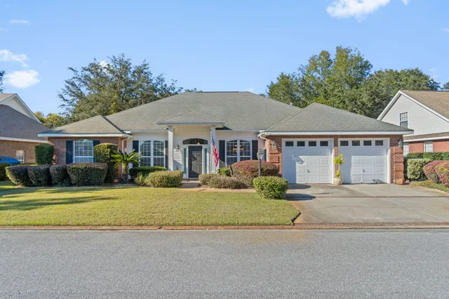a front view of a house with a garden and yard