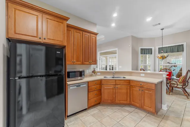a kitchen with a sink refrigerator and cabinets