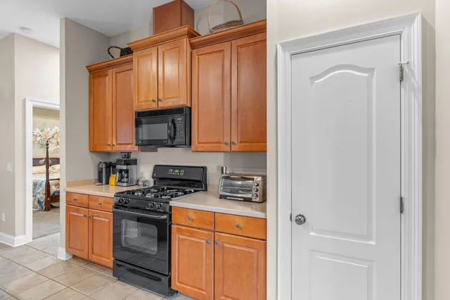 a kitchen with stainless steel appliances granite countertop a stove a sink and a refrigerator with wooden cabinets