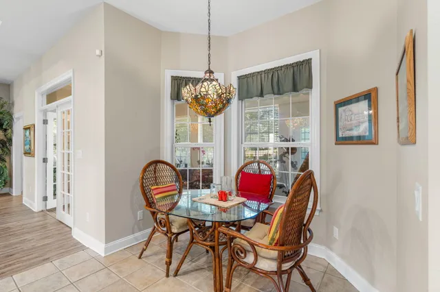 a dining room with furniture a chandelier and window
