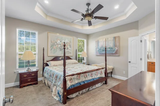 a bedroom with a bed chandelier and a window