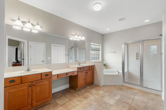 a large bathroom with a large tub sink vanity and granite