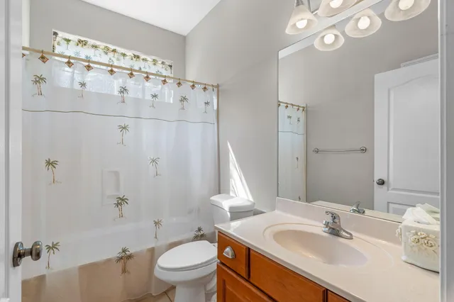 a bathroom with a sink vanity granite toilet and shower